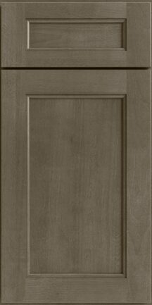 Close up of a brown wooden cabinet door with a raised center panel and surrounding frame